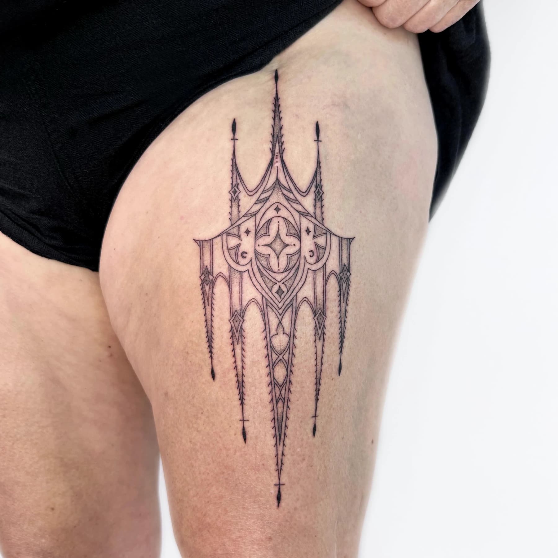 Gothic architectural scar cover-up tattoo on the thigh by Nika Osseili.