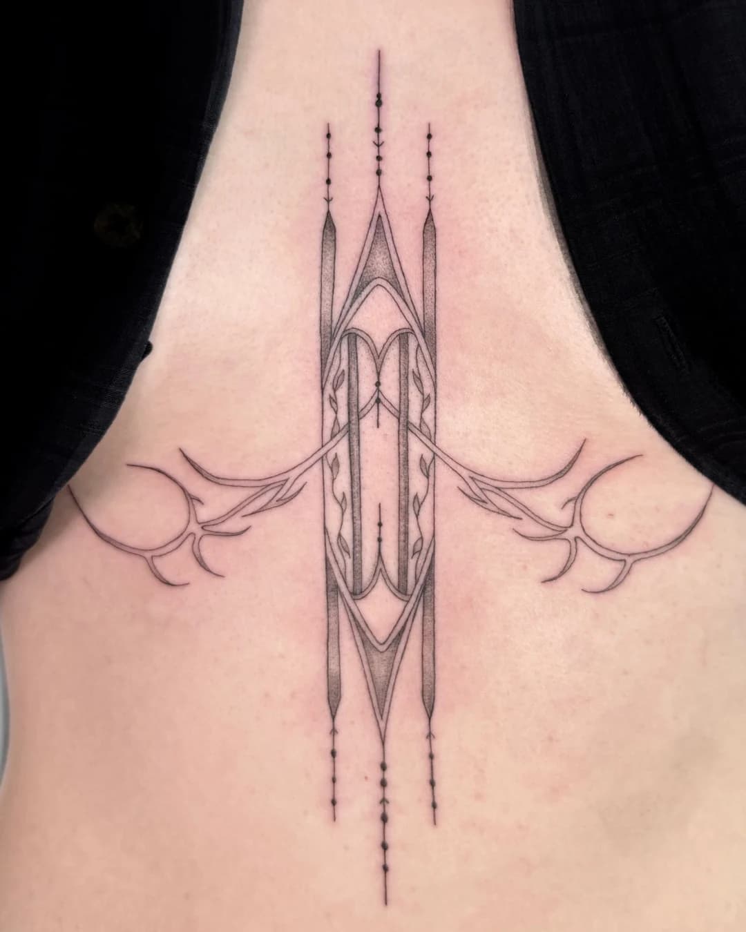 Fine line architectural sternum tattoo by Nika Osseili.