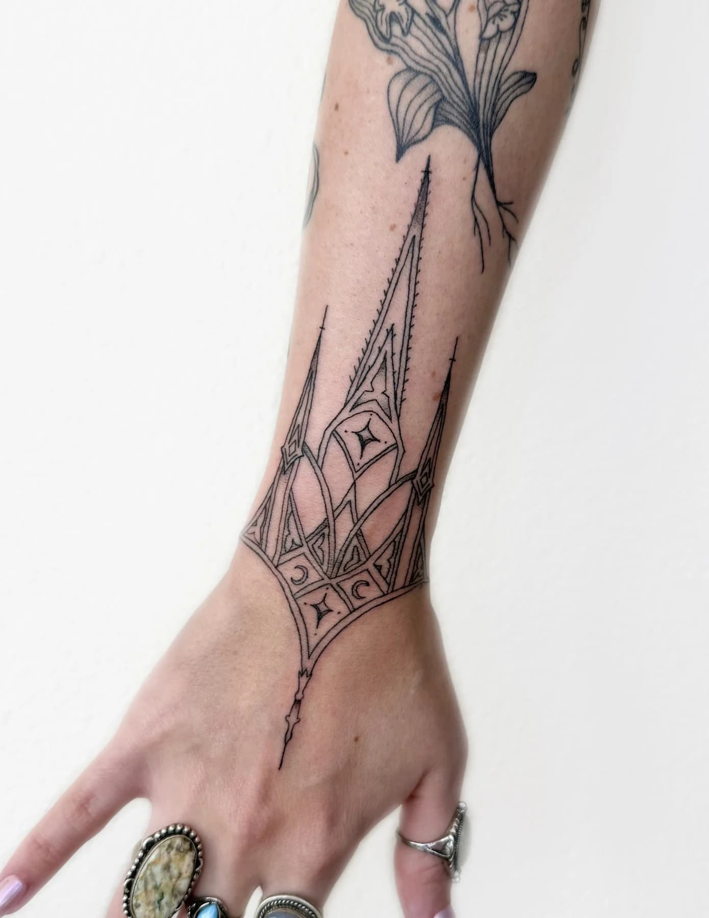 Gothic architecture fine line tattoo on the wrist and hand by Nika Osseili.