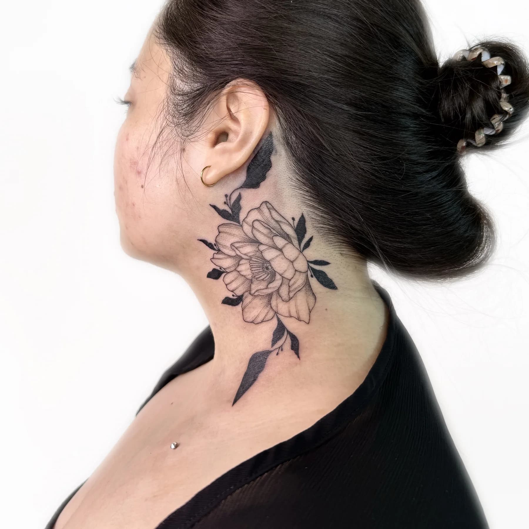 Botanical fine line flower neck tattoo with blackwork details by Nika Osseili