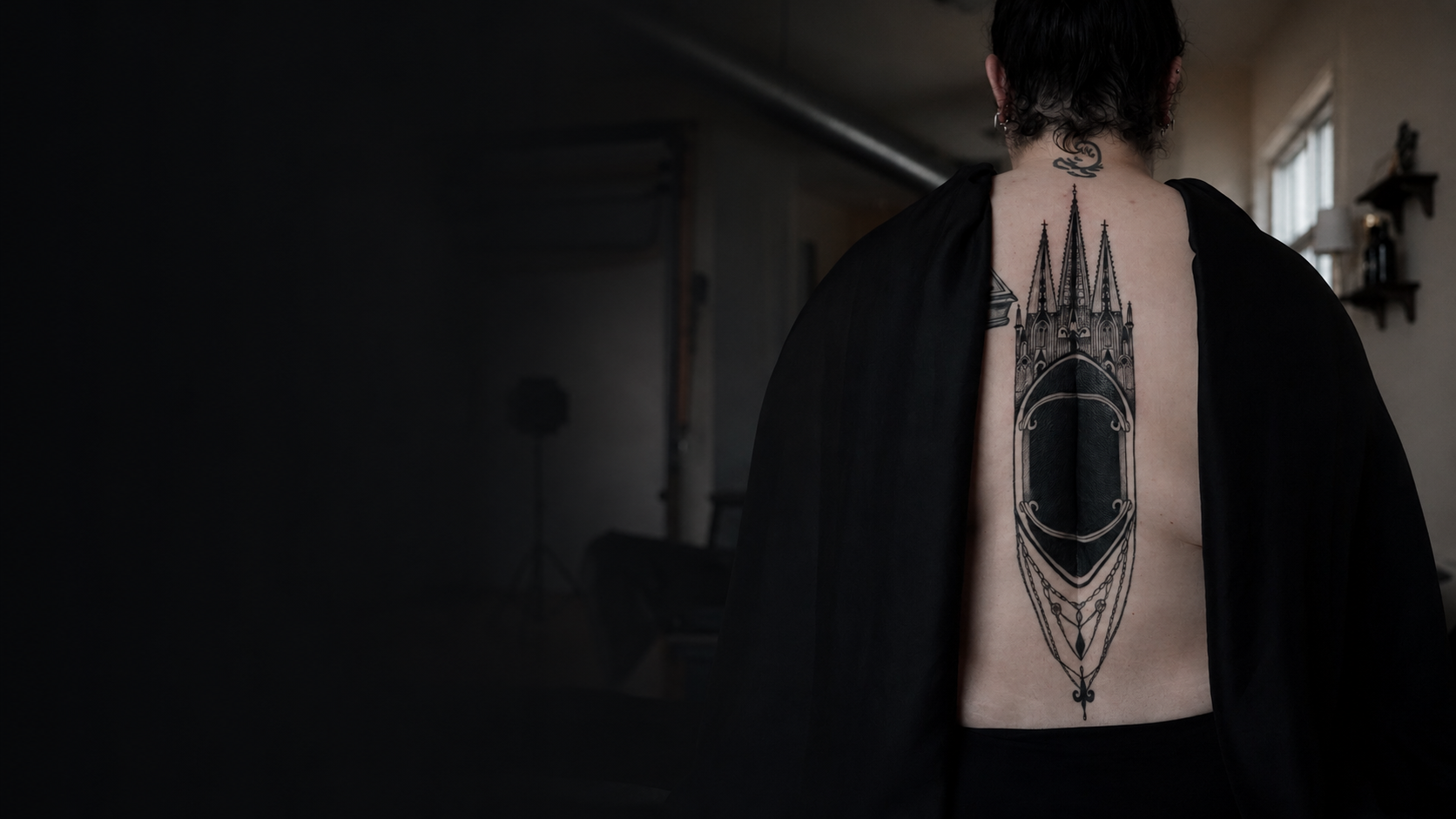 Gothic fine line back tattoo by Nika Osseili.